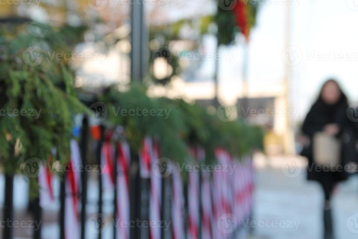 blurry background of candycane lights and garland up with woman holiday shoppping photo