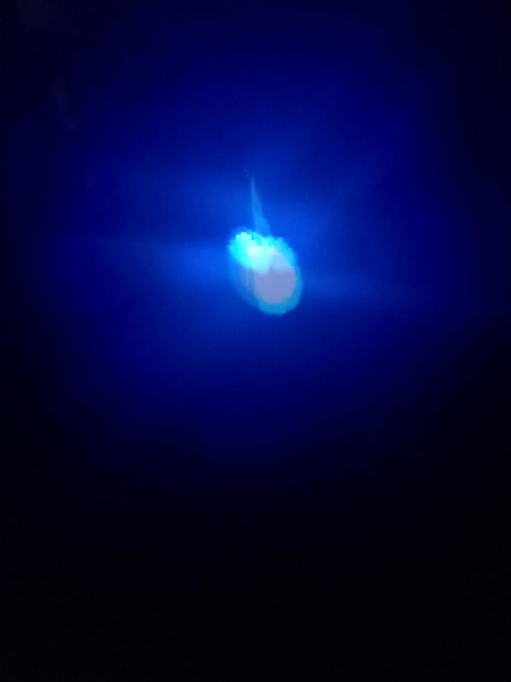 punto de luz azul sobre un fondo oscuro foto