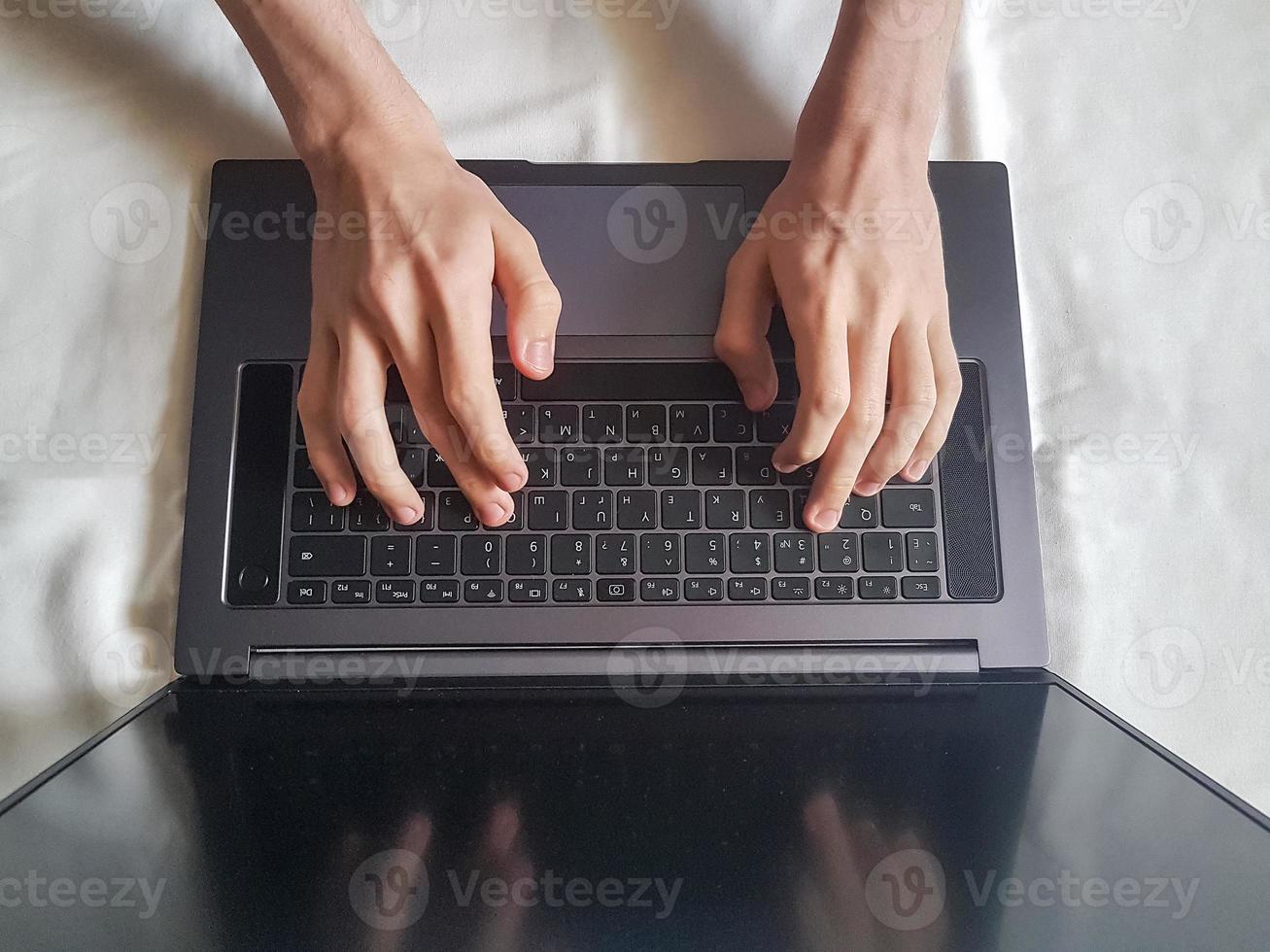 Male hands typing on laptop keyboard photo