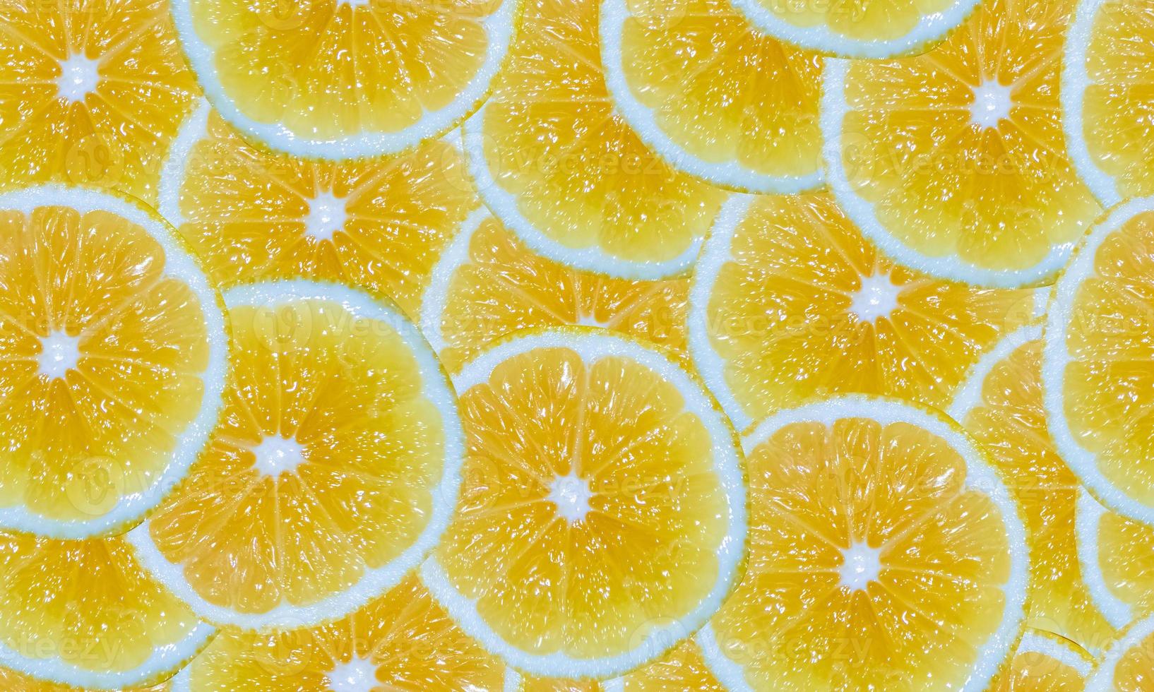 Lemon slices seamless background. Cut yellow citrus fruit. photo