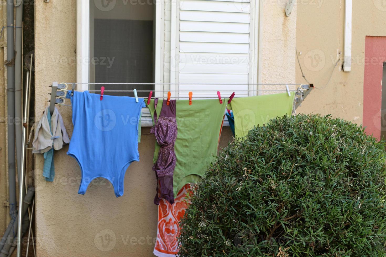 Washed clothes and linen dries on the balcony. photo