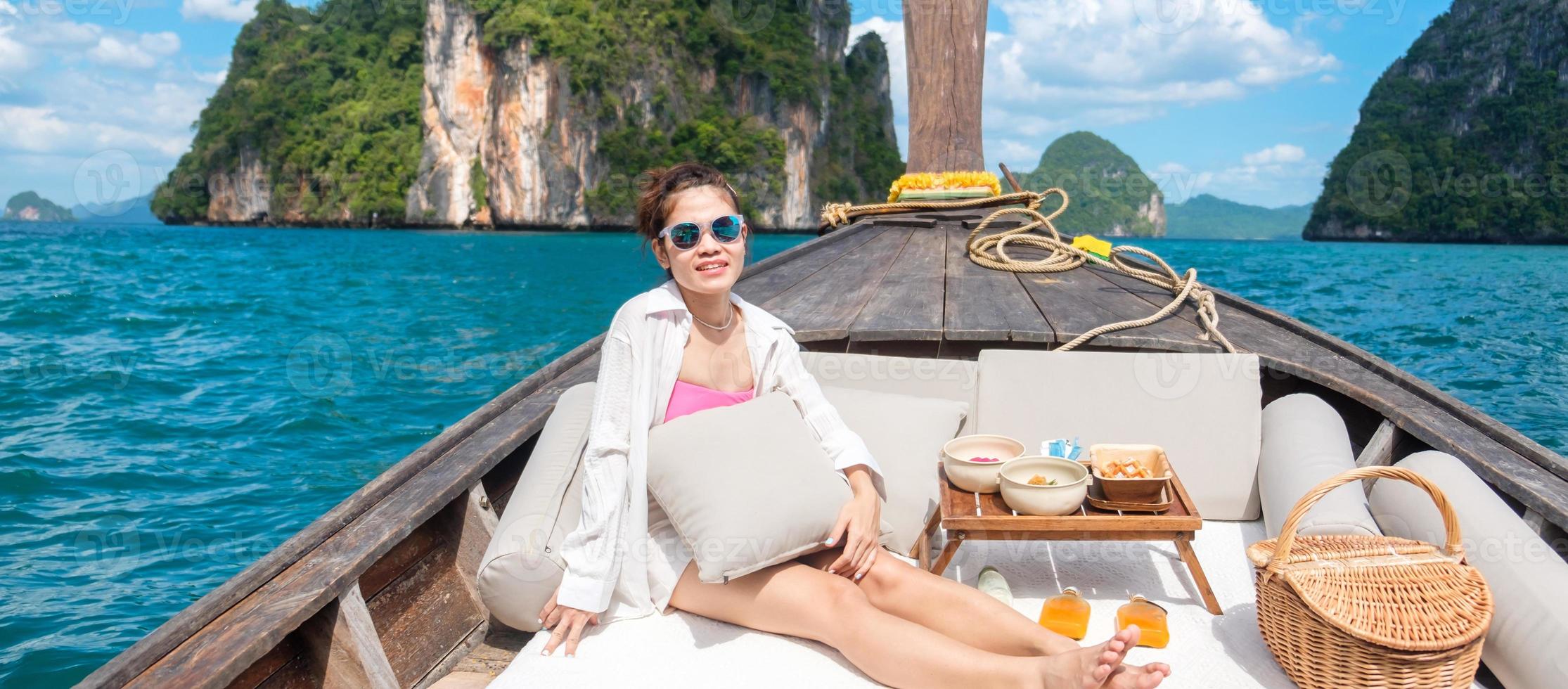 mujer turista en un viaje privado en bote de cola larga a la isla con un picnic de comida exótica, krabi, tailandia. punto de referencia, destino, viajes asiáticos, vacaciones, pasión por los viajes y concepto de vacaciones foto