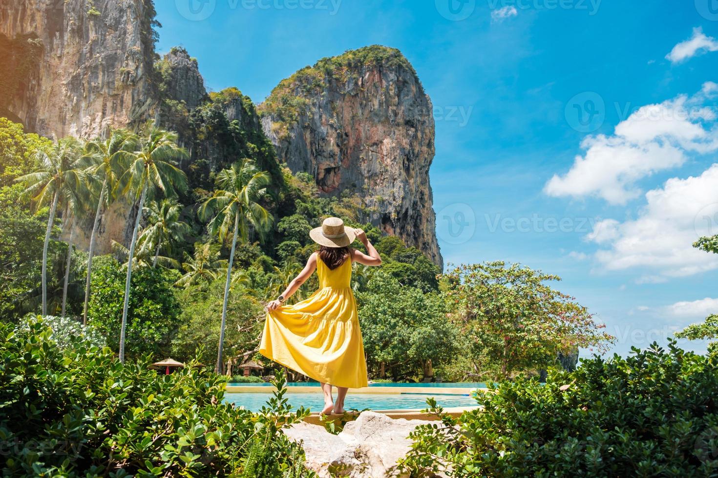 mujer turista en vestido amarillo y sombrero viajando en la playa de railay, krabi, tailandia. concepto de vacaciones, viajes, verano, pasión por los viajes y vacaciones foto