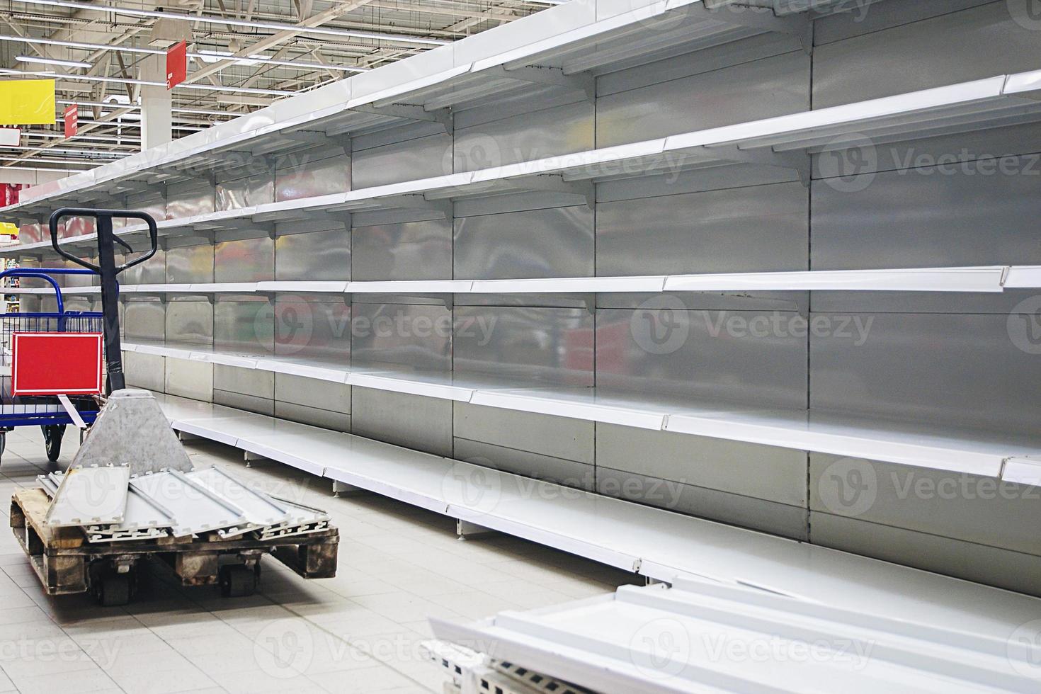 estantes vacíos y transpaletas en la tienda de comestibles foto