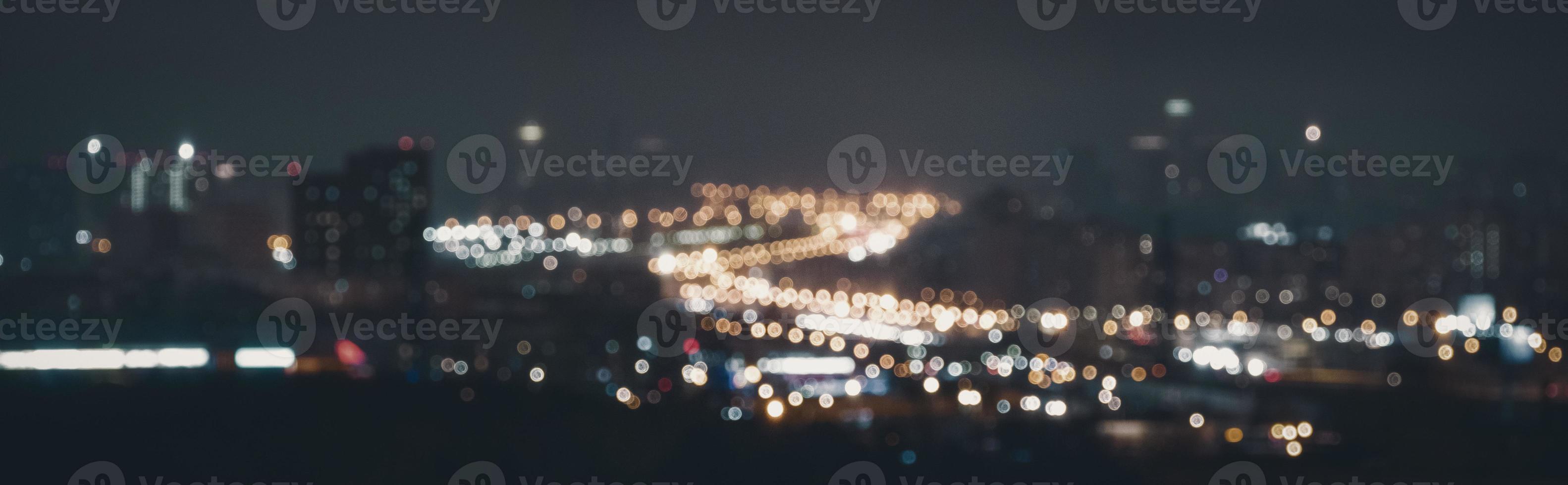 Blurry lights of road traffic at night, abstract unfocused cityscape background photo
