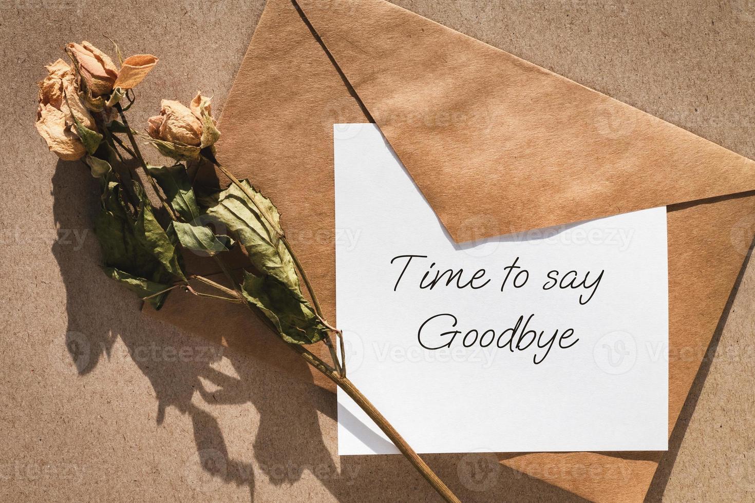 Time to say goodbye note, envelope and dry roses photo