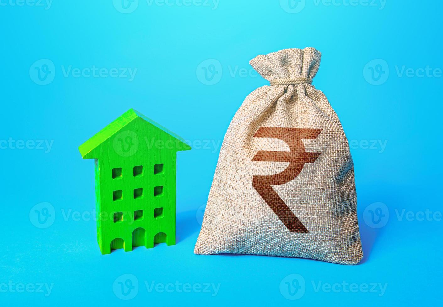 Indian rupee money bag and green Resident building. Investment in green technologies. Reduced emissions and improved energy efficiency. Reducing impact on environment. Investments in housing. photo