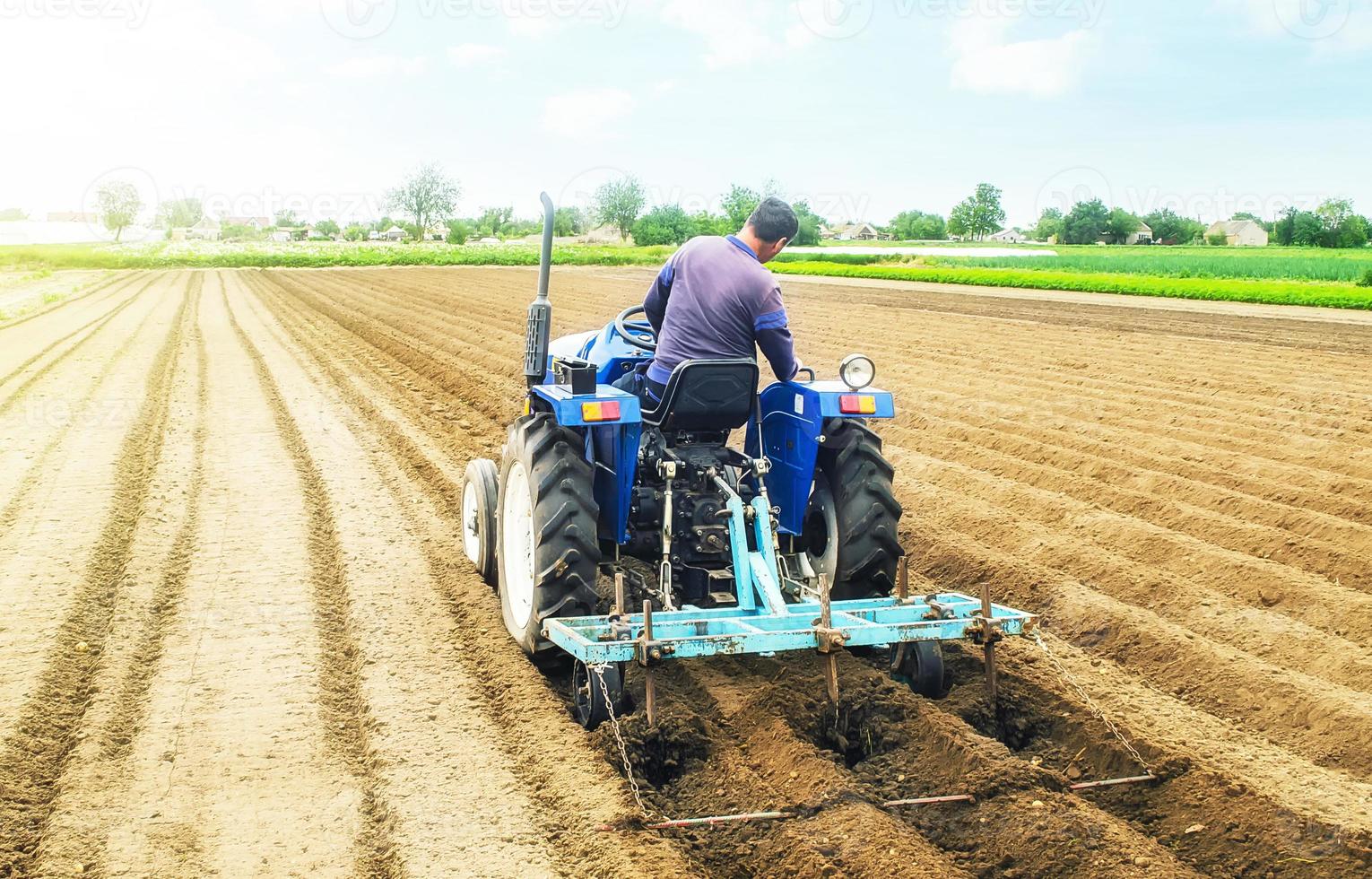 Farmer on a tractor making ridges and mounds rows on a farm field