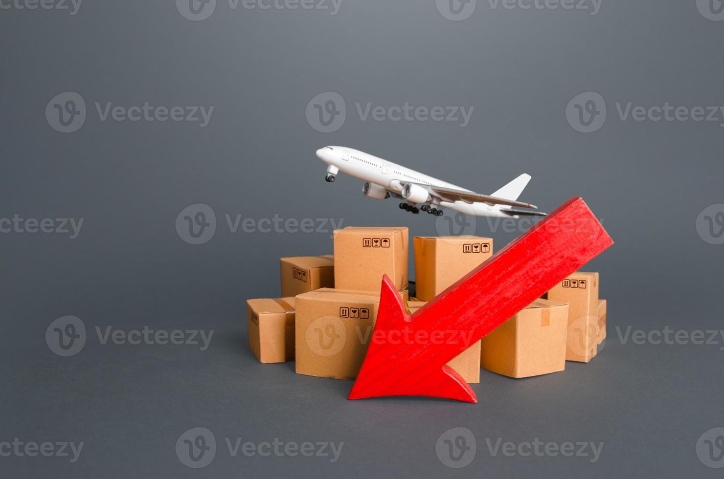 Airplane over boxes and red down arrow. Decline of goods transportation volume, world trade traffic delays. Delivery by air. High demand and low proposition for express delivery. Cargo aircraft photo