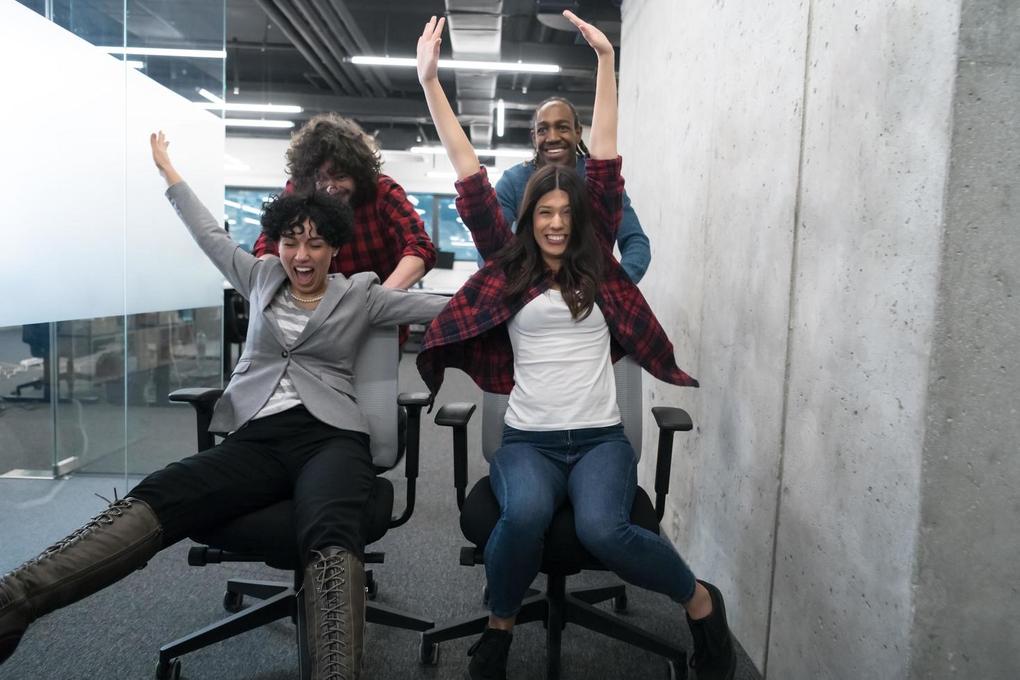 equipo de negocios multiétnico corriendo en sillas de oficina foto