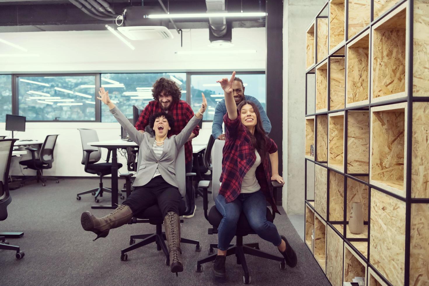 equipo de negocios multiétnico corriendo en sillas de oficina foto