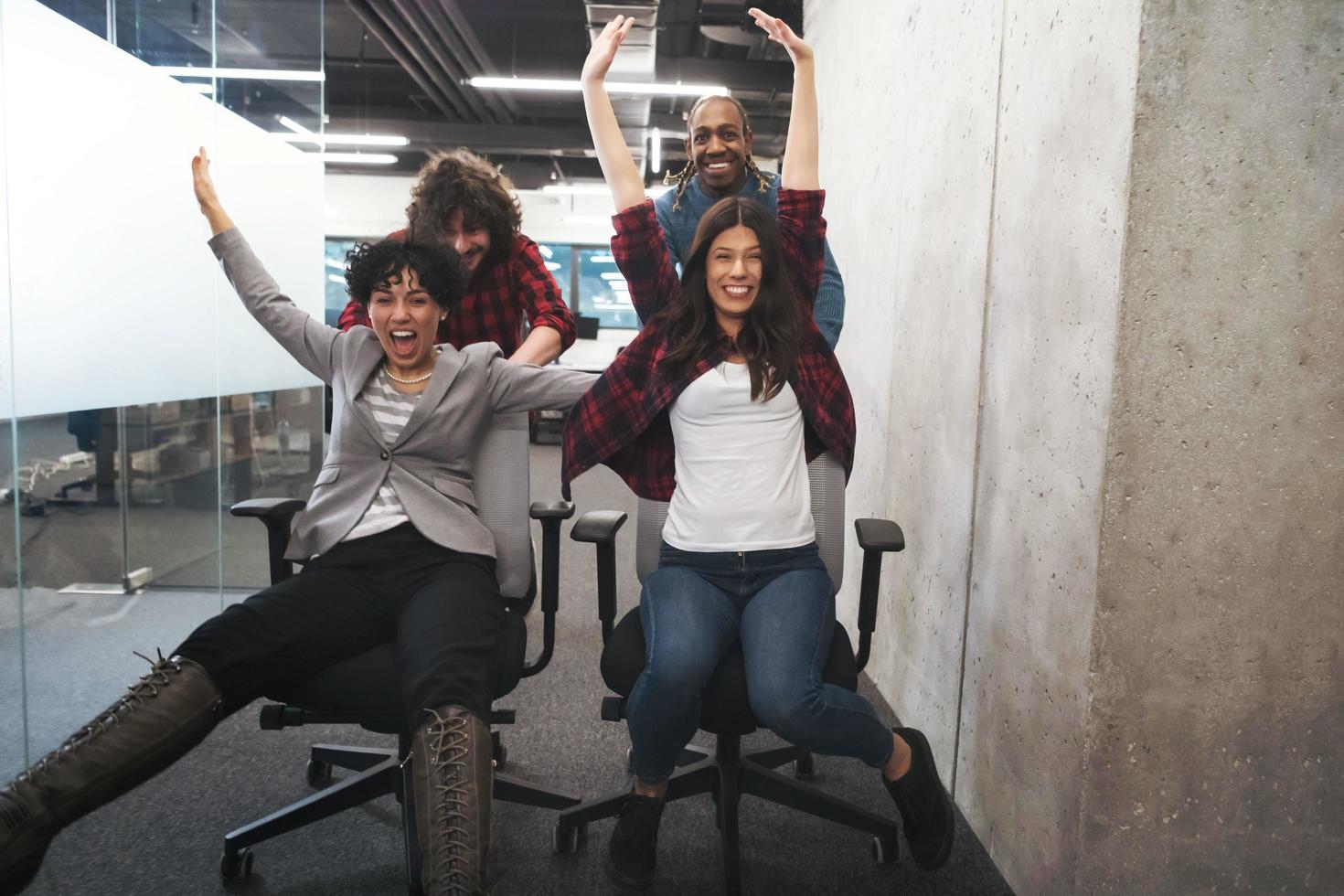 equipo de negocios multiétnico corriendo en sillas de oficina foto