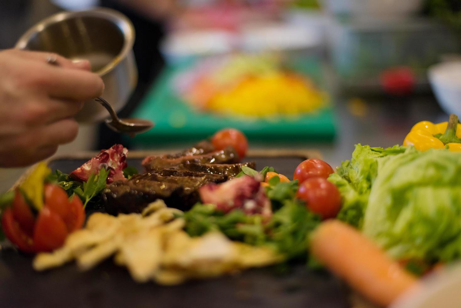 Chef finishing steak meat plate photo