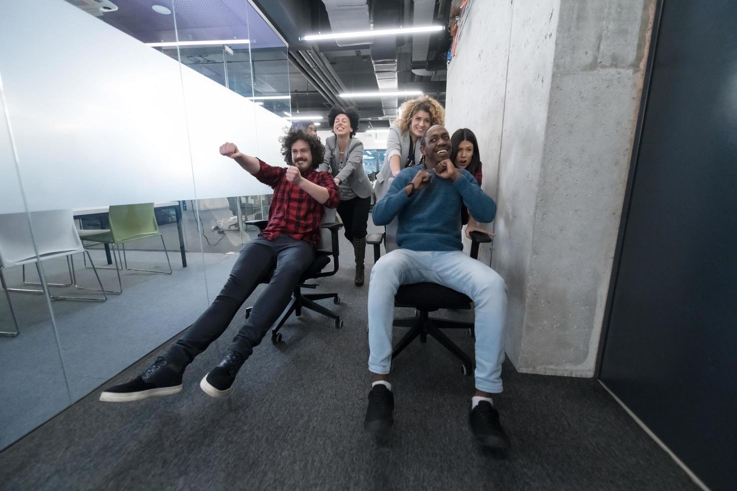 multiethnics business team racing on office chairs photo