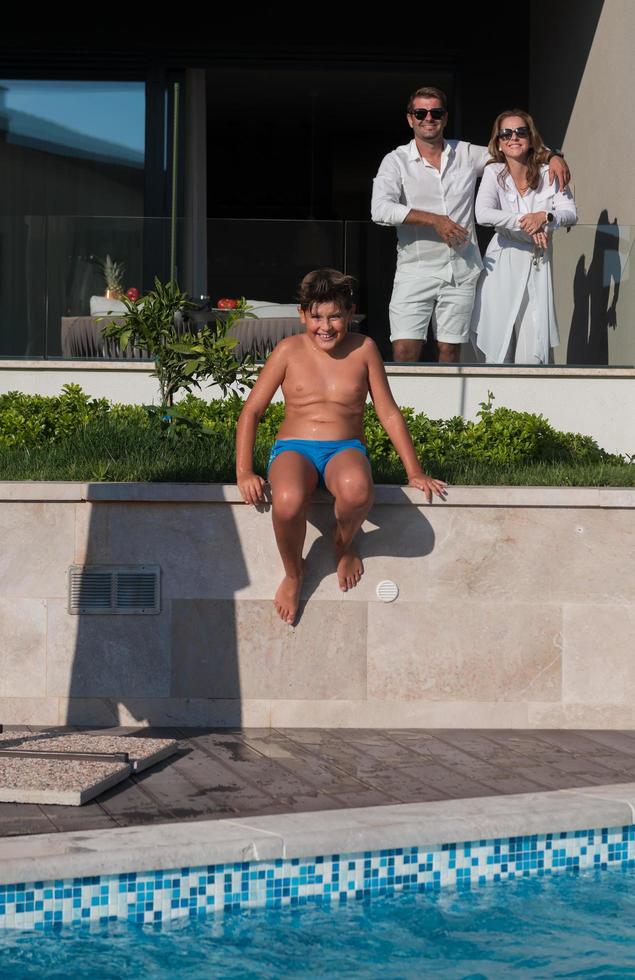 Happy family enjoys vacation in a luxury house with pool. Senior couple spends time with their son during the vacation. Selective focus photo