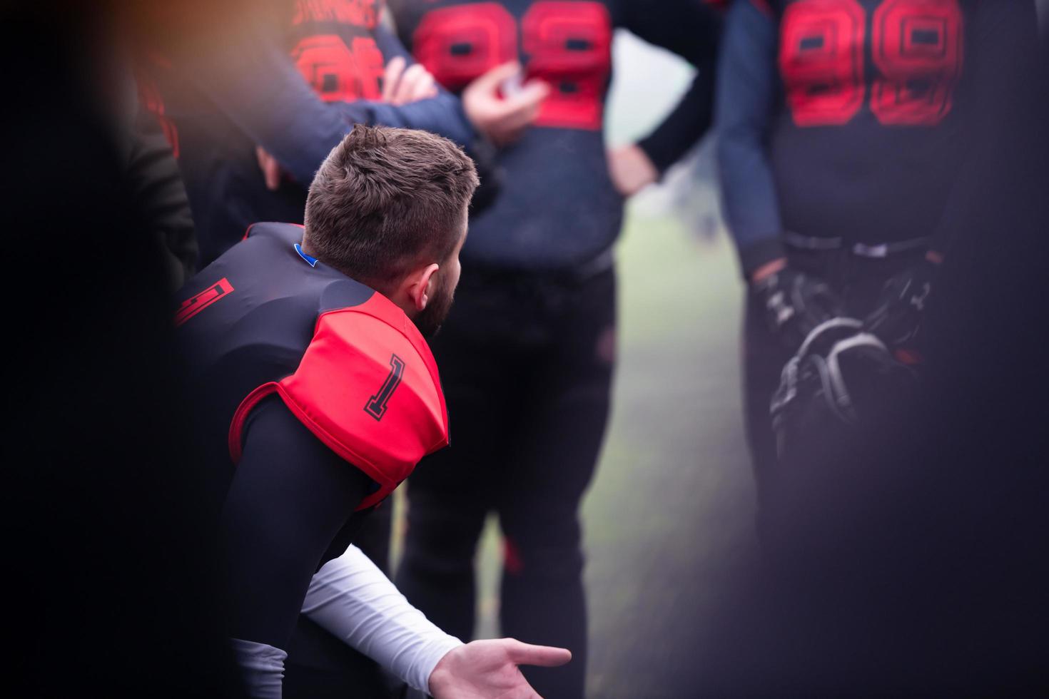 american football player discussing strategy with his team photo