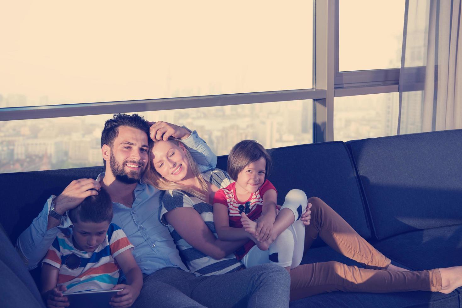 feliz pareja joven pasando tiempo con los niños en casa foto