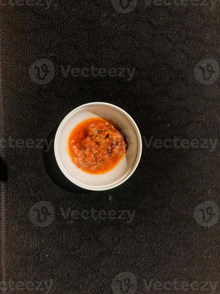 Chili sauce in a white container photo