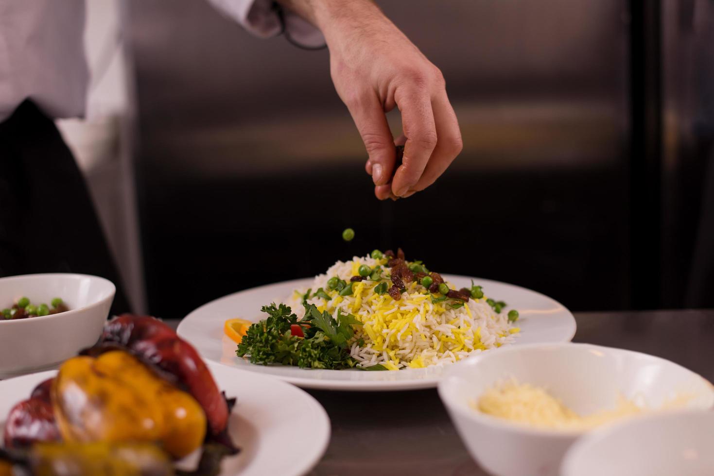 Chef hands serving vegetable risotto photo