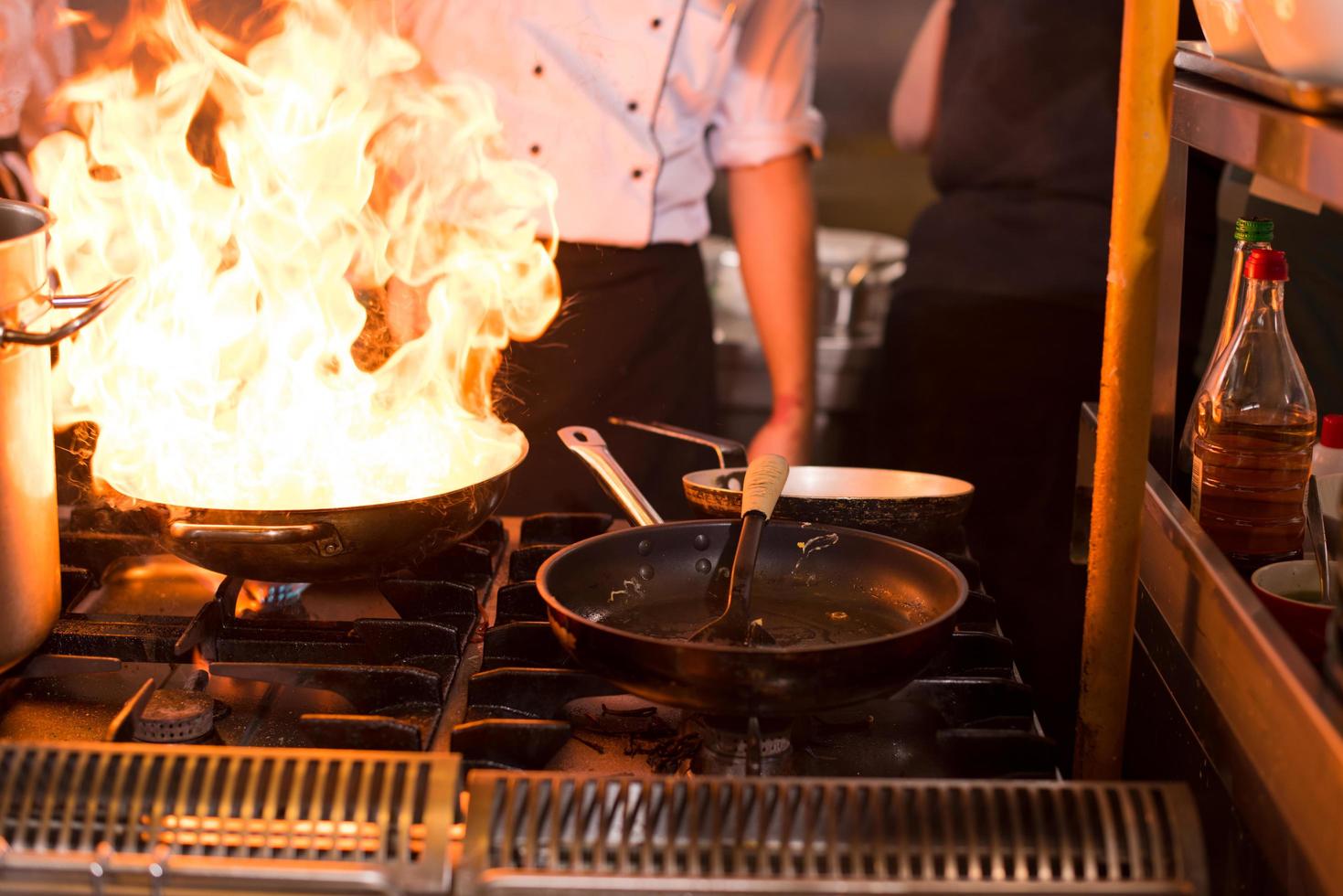 chef haciendo flambeado en la comida foto