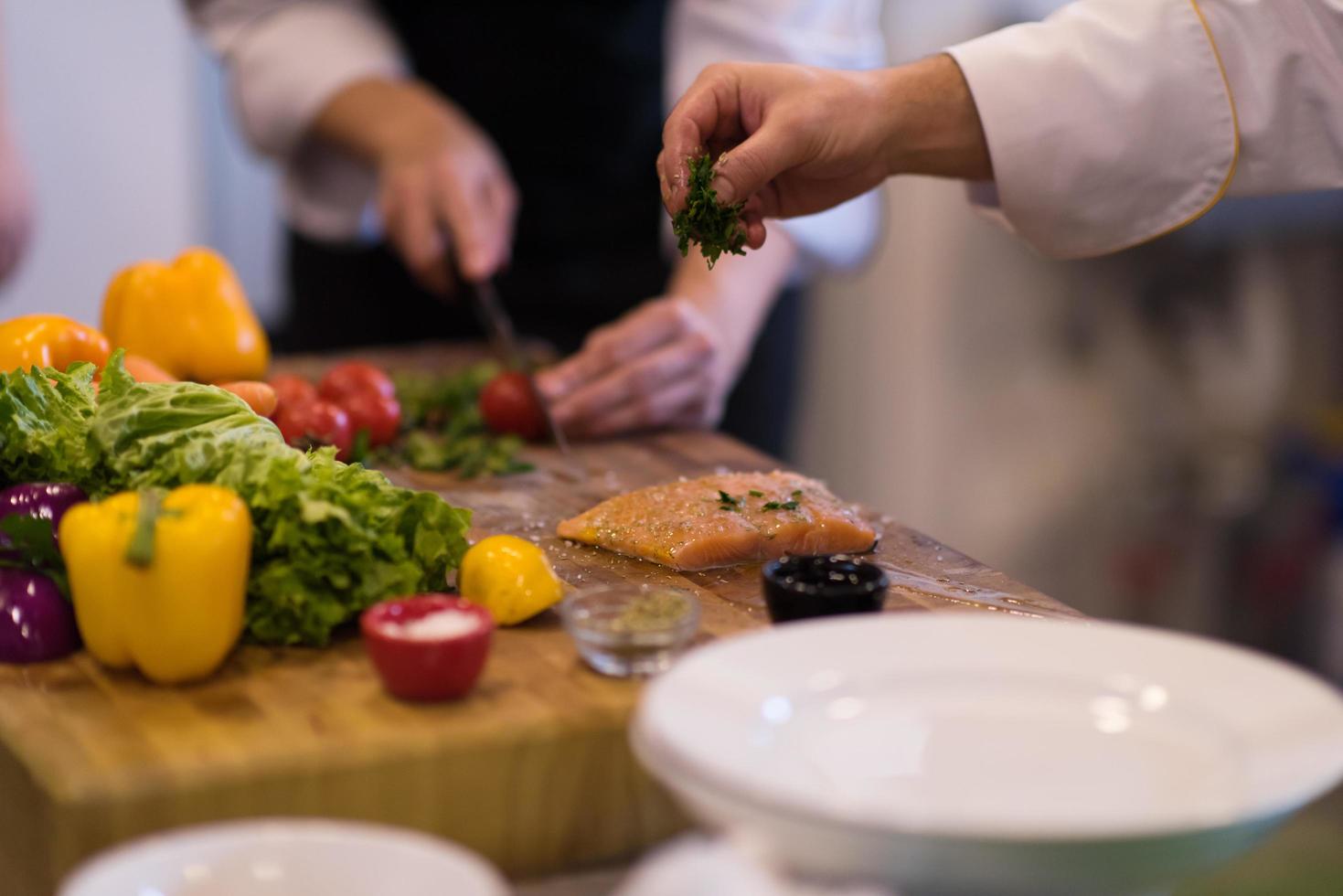 Chef hands preparing marinated Salmon fish photo