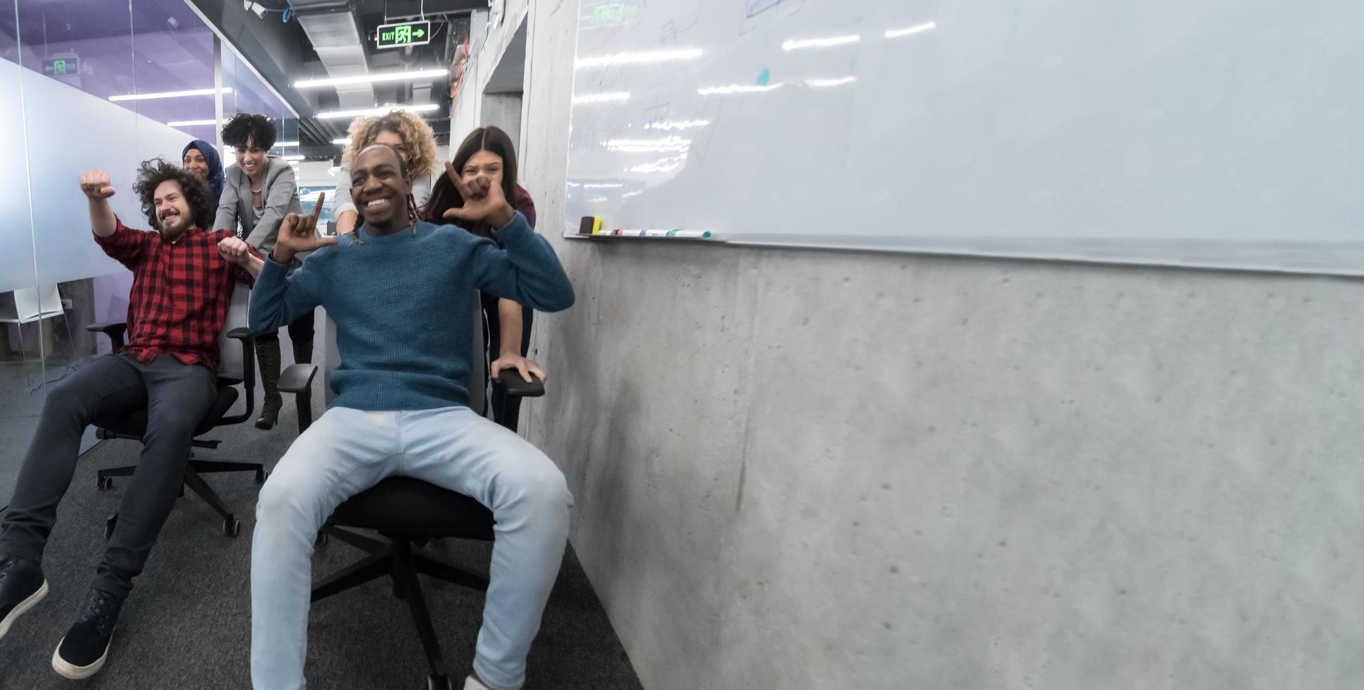 multiethnics business team racing on office chairs photo