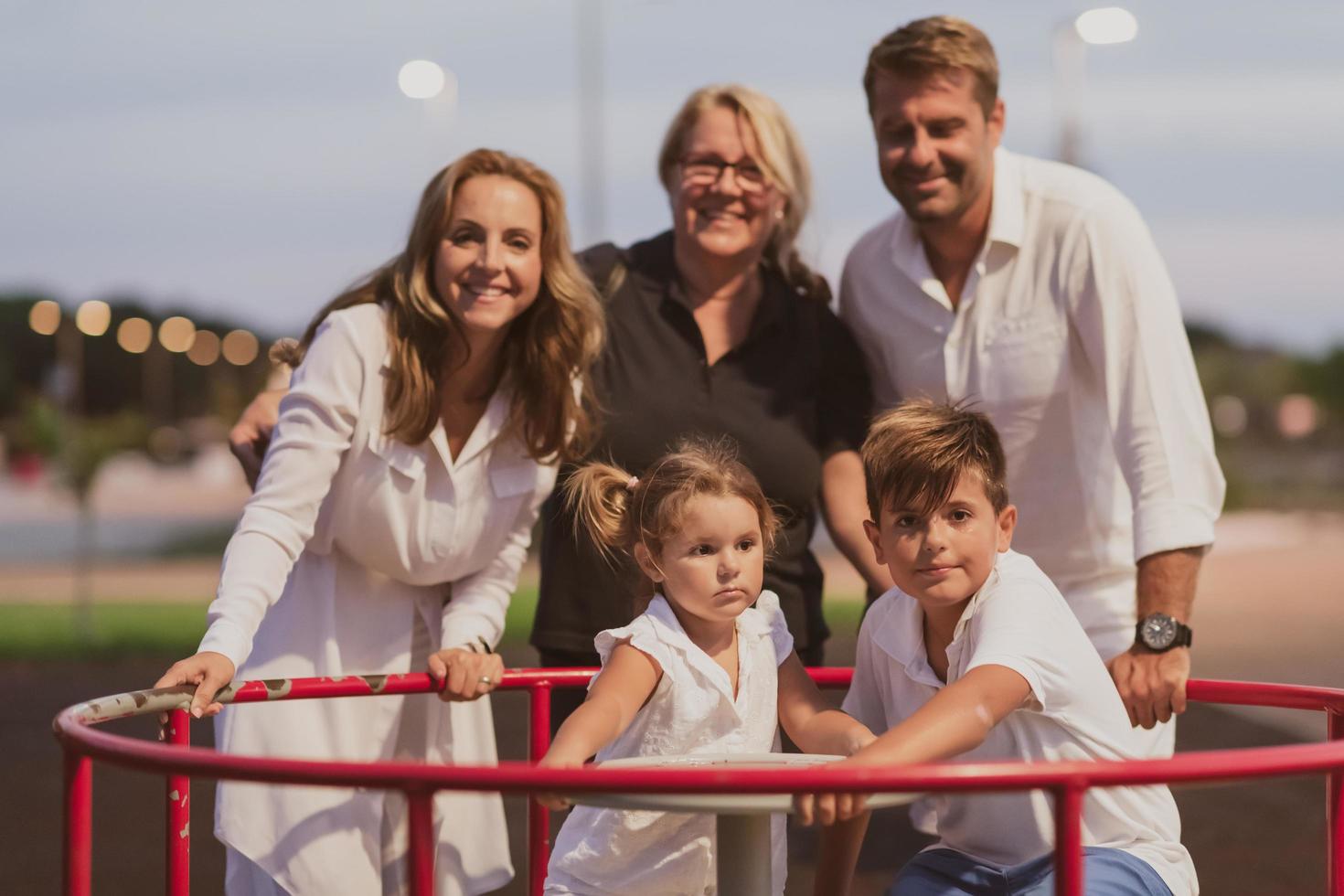 una pareja de ancianos con ropa informal con sus hijos y su abuela pasan tiempo juntos en el parque de vacaciones. tiempo familiar. enfoque selectivo foto