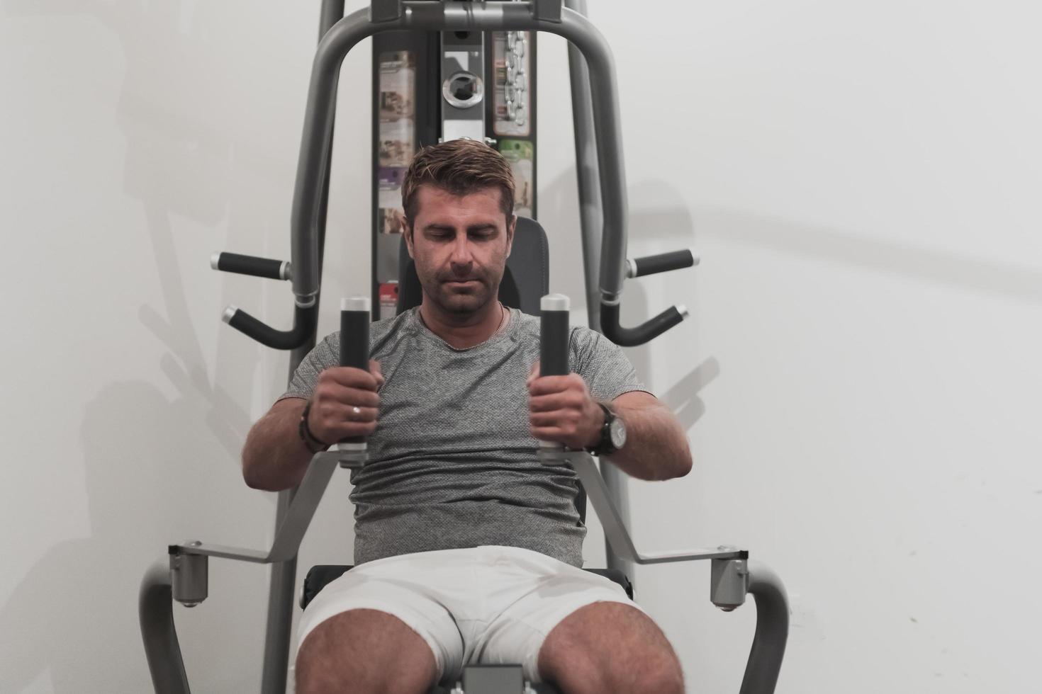 Struggling with age. Confident senior man exercising in health club. Selective focus photo