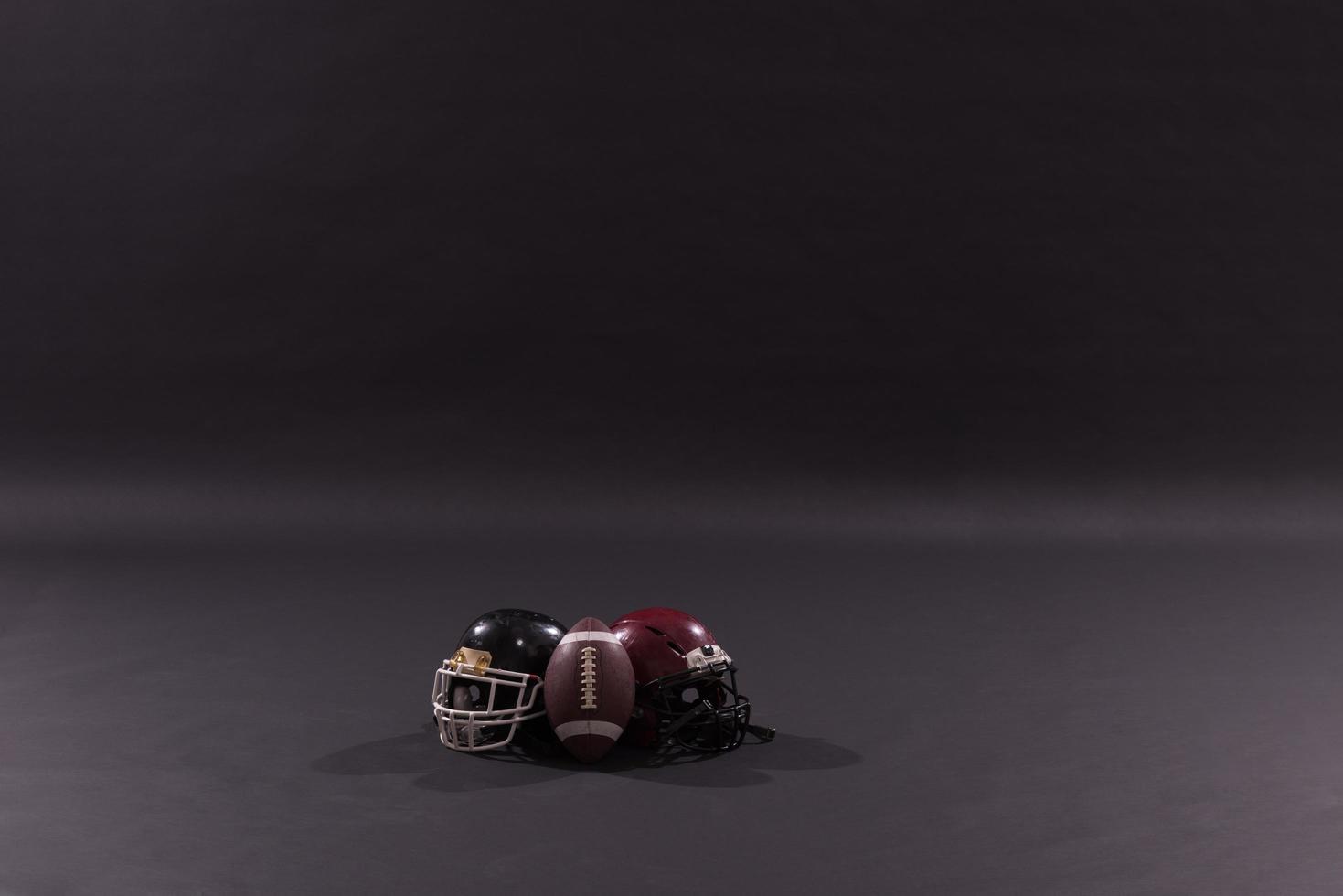 american football and helmets isolated on gray photo