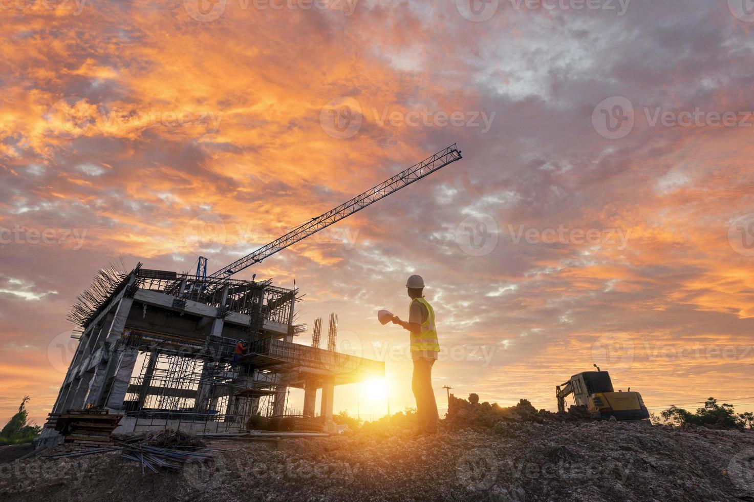 Engineer on a construction site passing by a construction site that blurs at sunset, an engineer inspects the construction of a water catchment tower photo