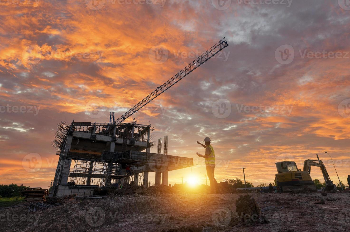 Engineer on a construction site passing by a construction site that blurs at sunset, an engineer inspects the construction of a water catchment tower photo