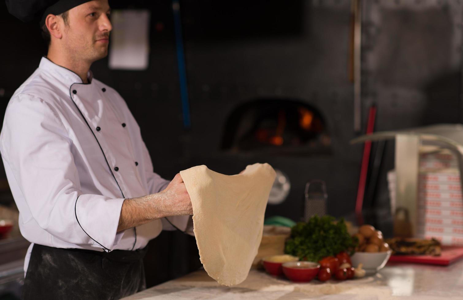 chef throwing up pizza dough photo