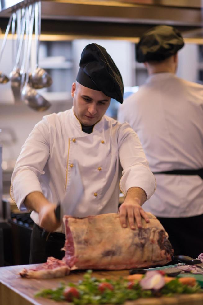 chef cutting big piece of beef photo