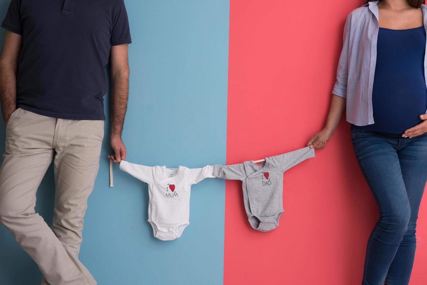 young couple holding baby bodysuits photo