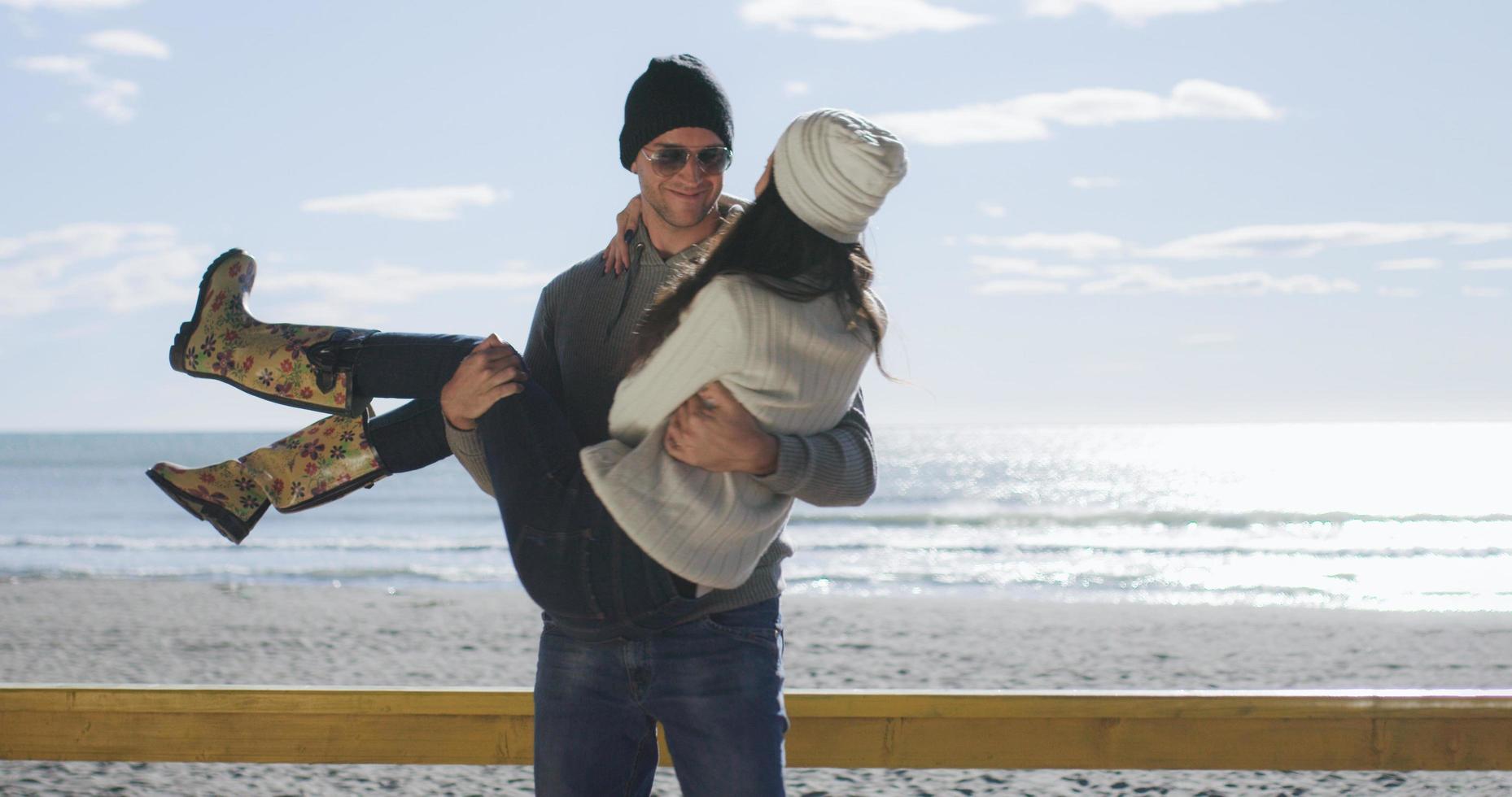 pareja divirtiéndose en un hermoso día de otoño en la playa foto