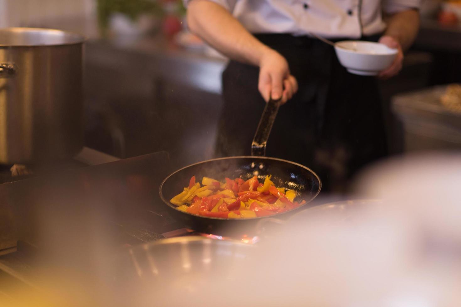 chef flipping vegetables in wok photo