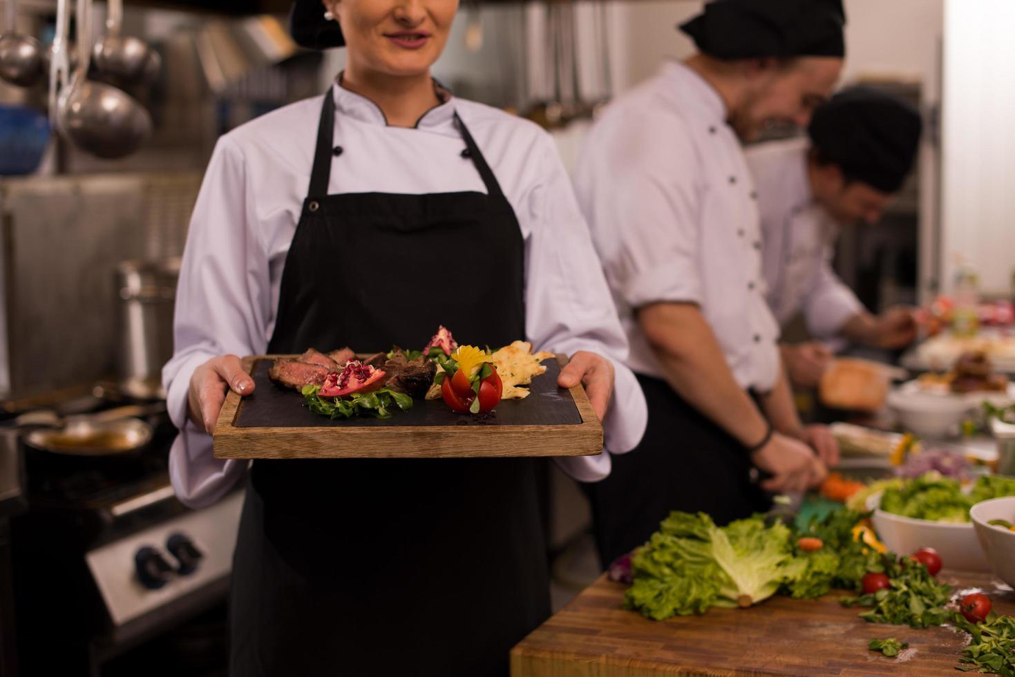 chef femenina sosteniendo un plato de bistec de ternera foto