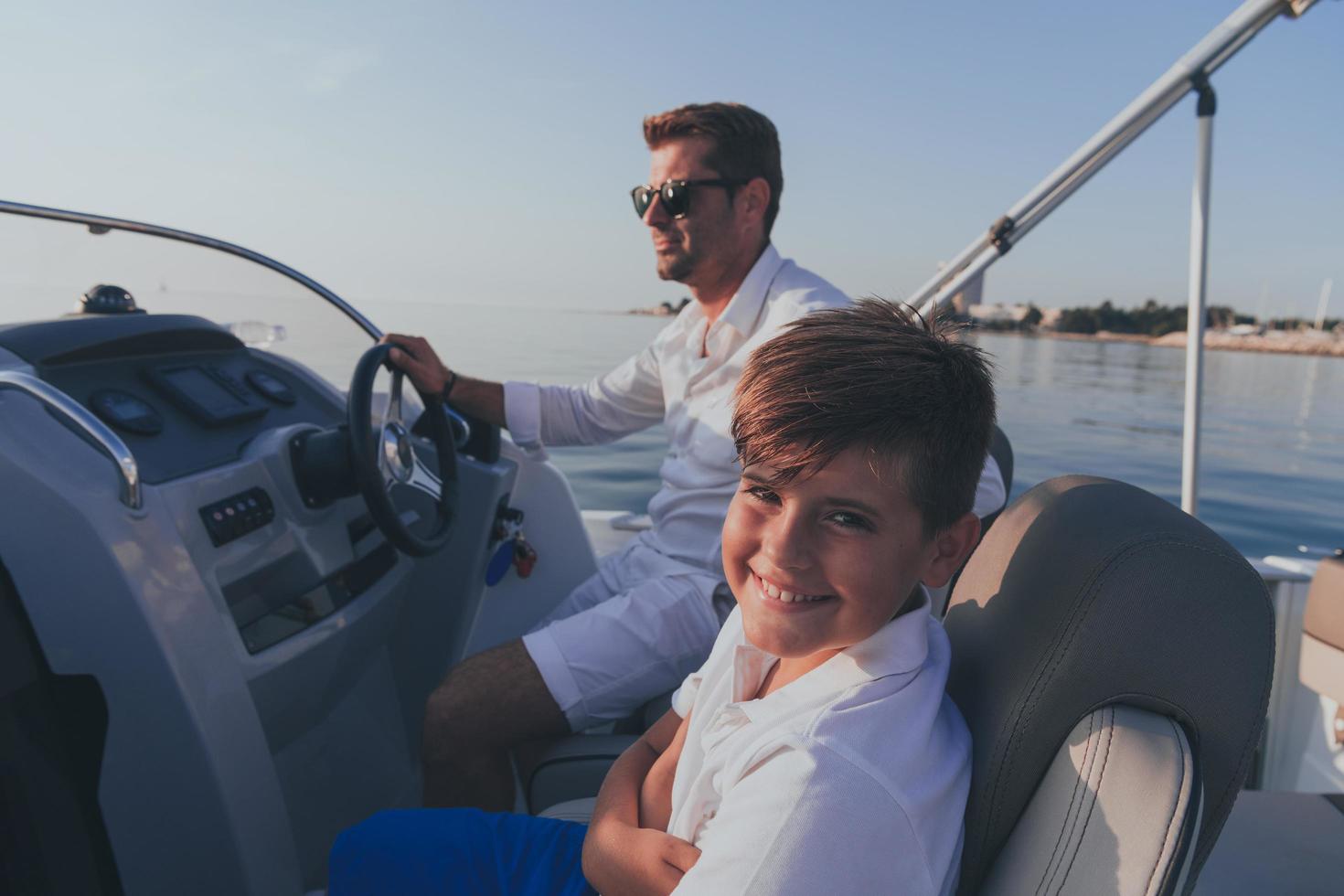 Father and son enjoy their vacation together while riding a luxury boat at sea. Selective focus photo