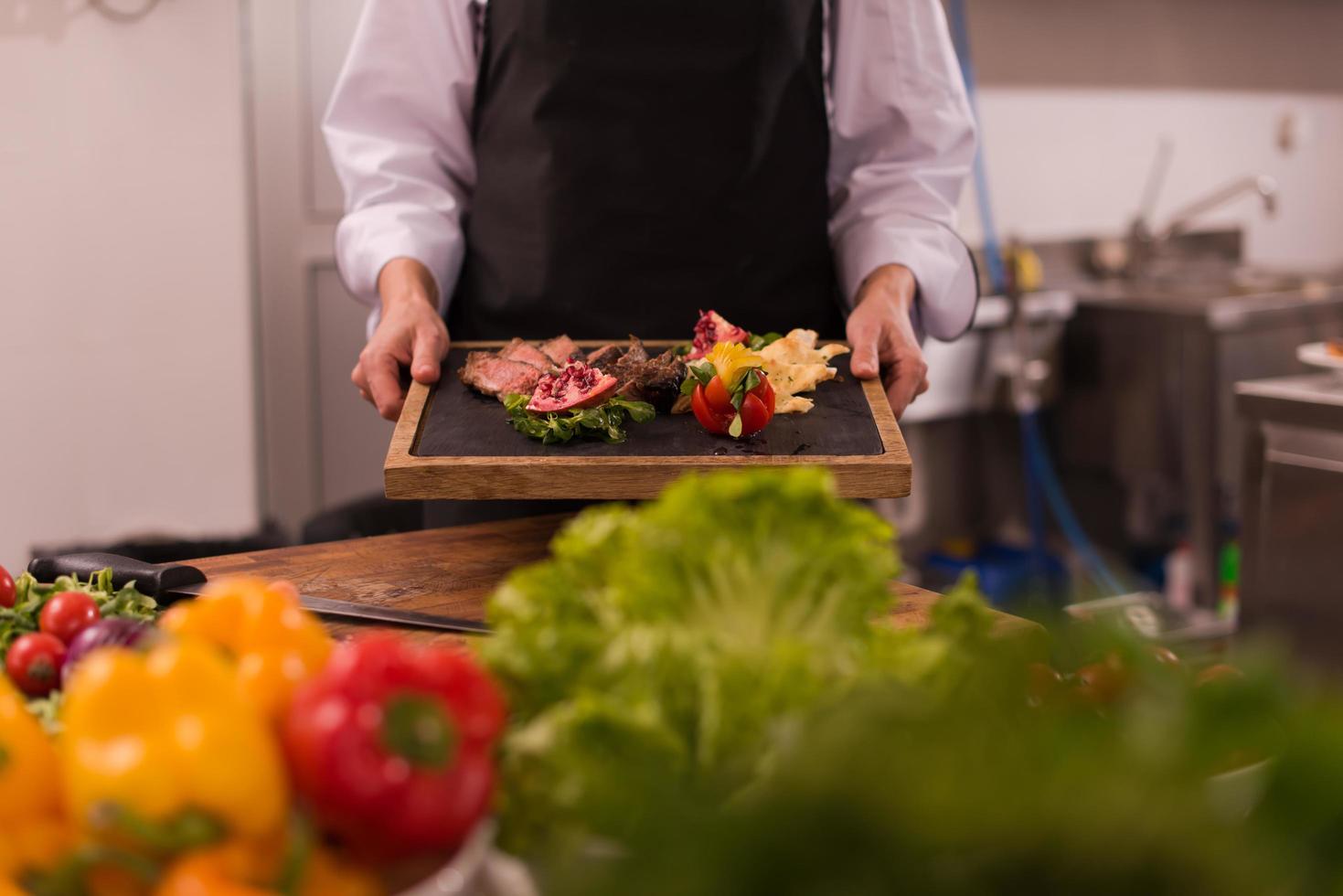 female Chef holding beef steak plate photo