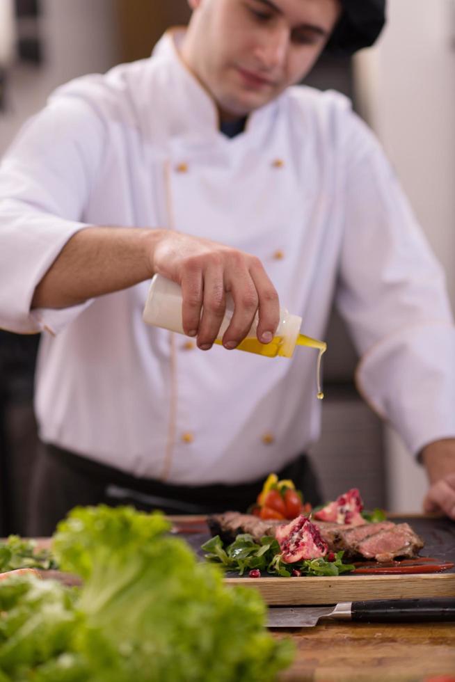 Chef finishing steak meat plate photo