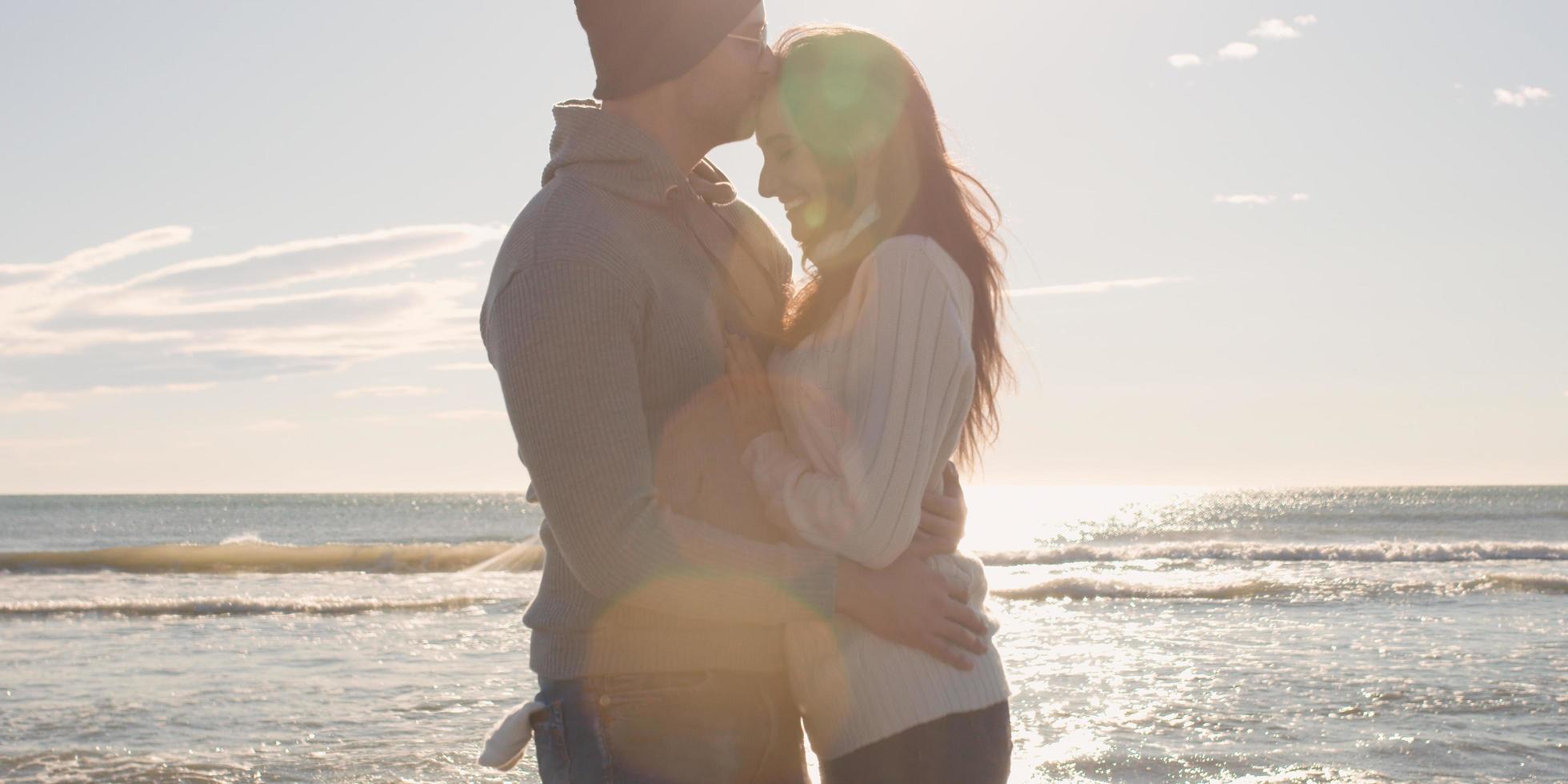 Couple having fun on beautiful autumn day at beach photo