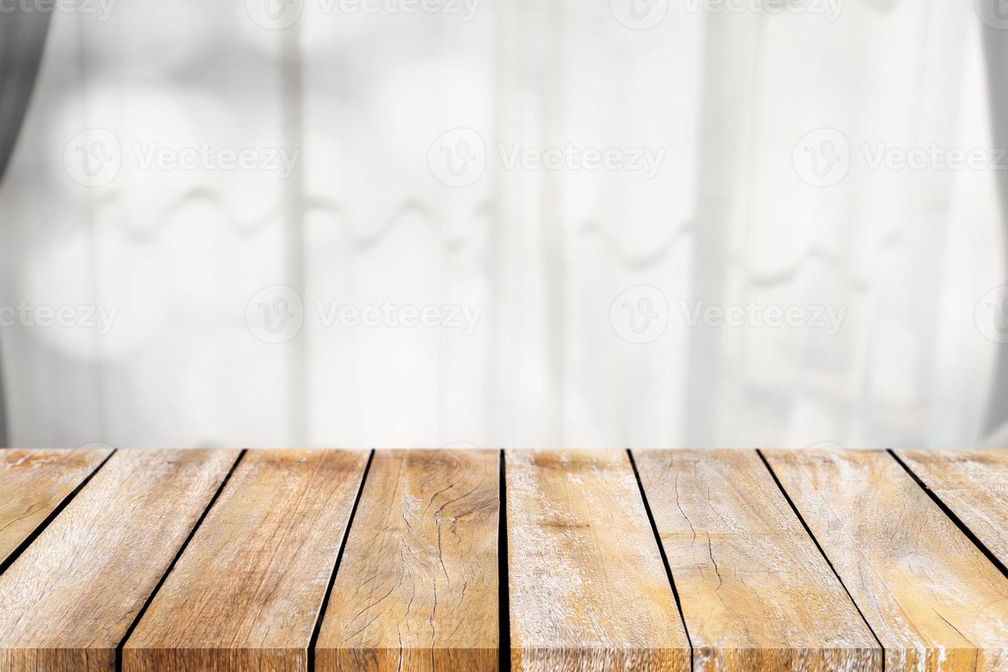 Empty of wooden table top on the blurry of the curtains around the window. For montage product display or design key visual layouts. photo