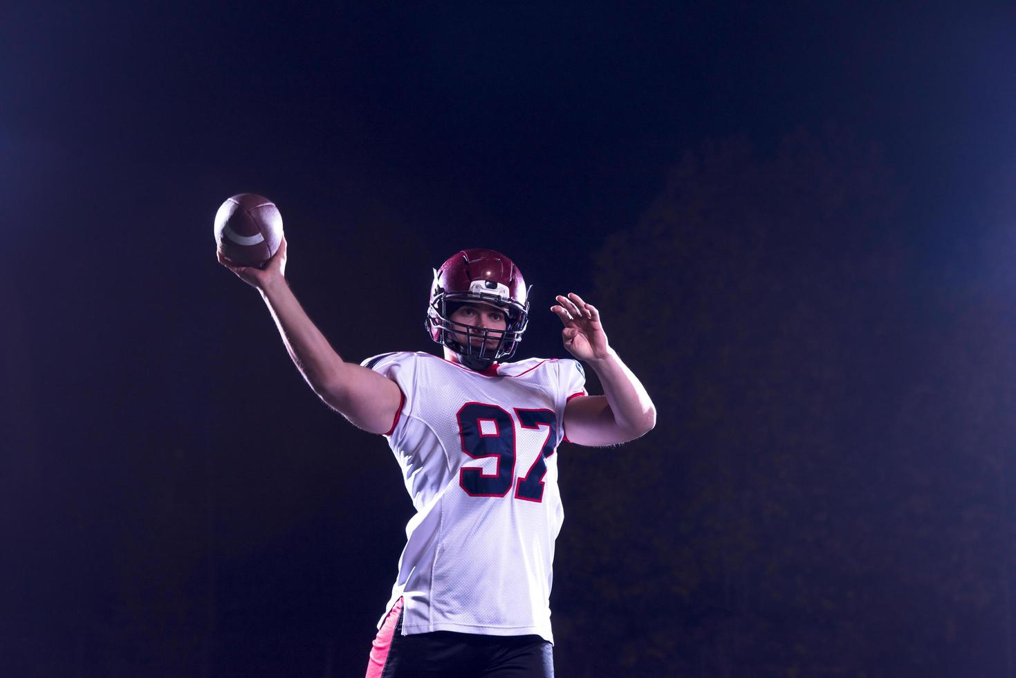 american football player throwing rugby ball photo