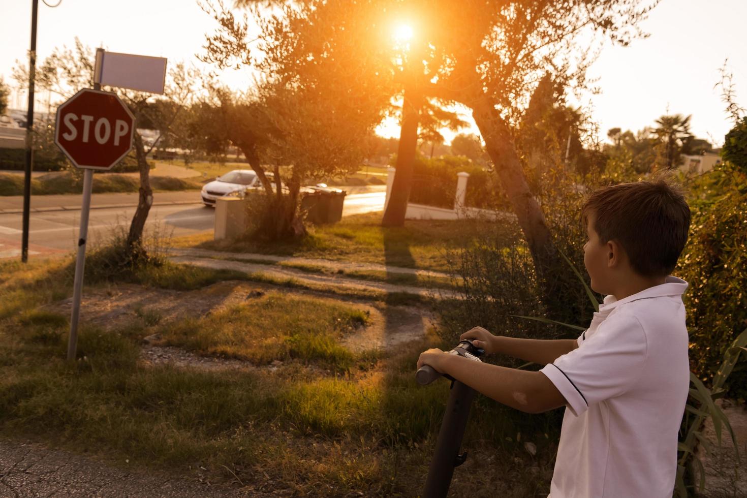 The boy rides an electric scooter in the early morning. Selective focus photo