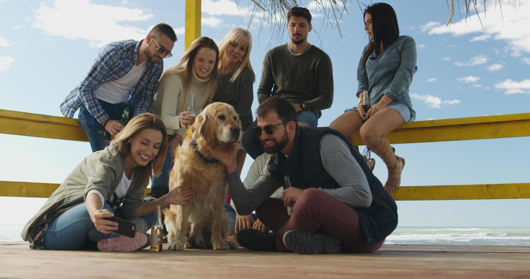 grupo de amigos divirtiéndose el día de otoño en la playa foto