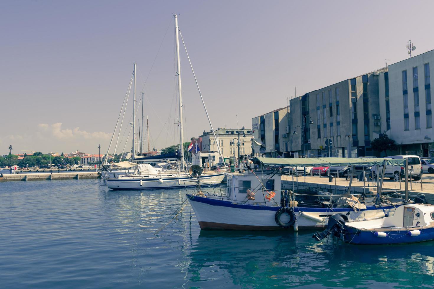 una fotografía de un barco y un yate de lujo anclados en el puerto. hermosa foto de un puerto mediterráneo