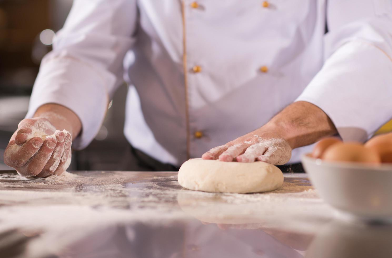 chef hands preparing dough for pizza photo