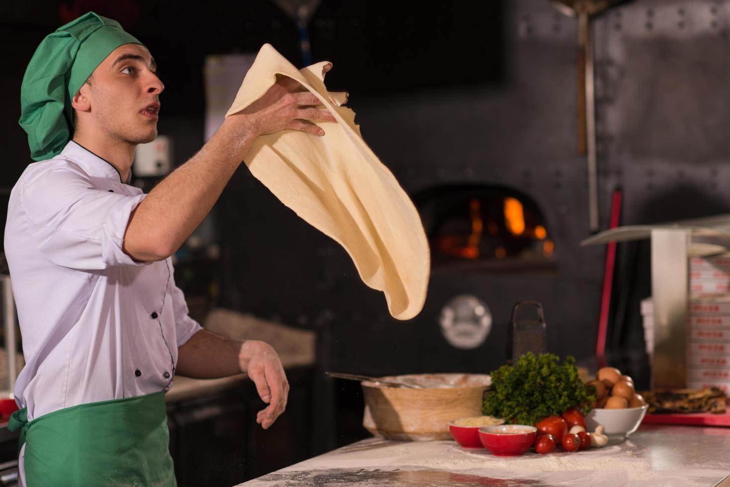 chef throwing up pizza dough photo