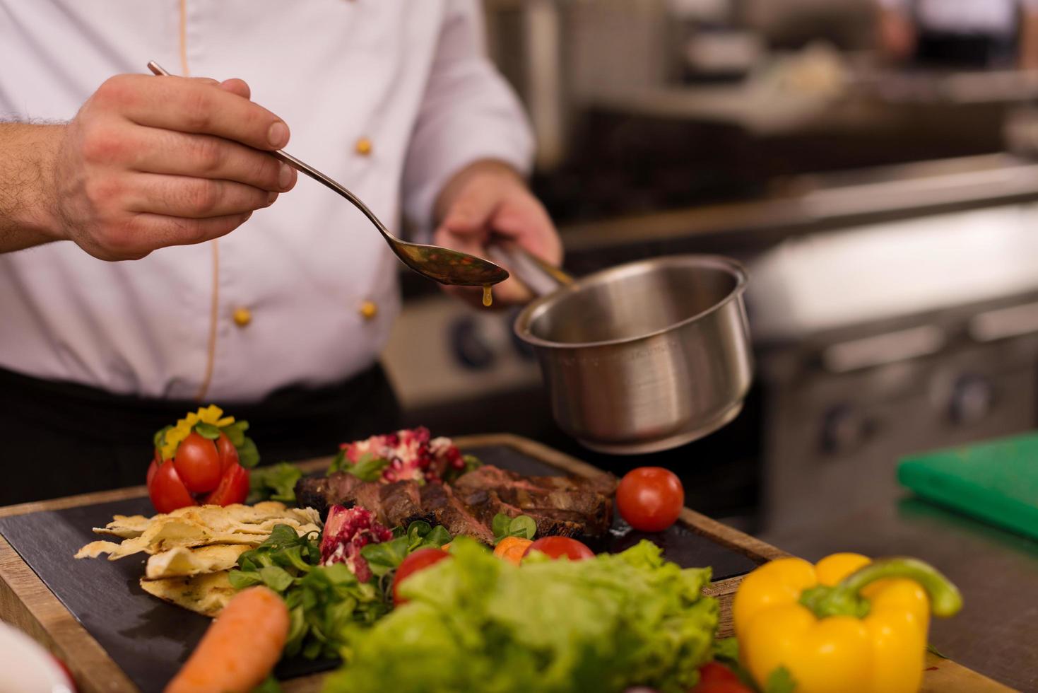 Chef finishing steak meat plate photo