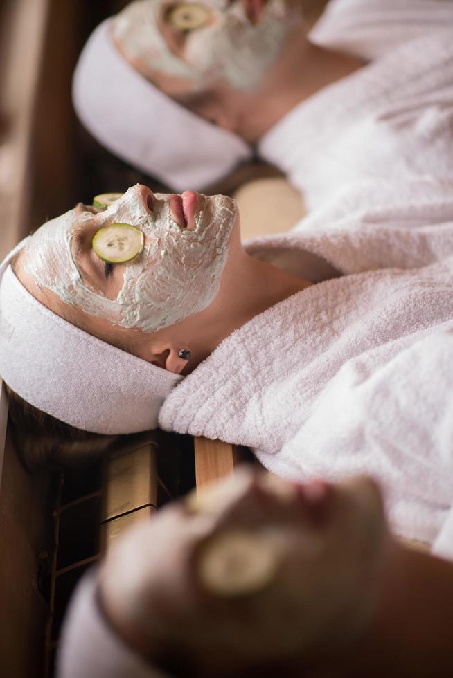 woman is getting facial clay mask at spa photo